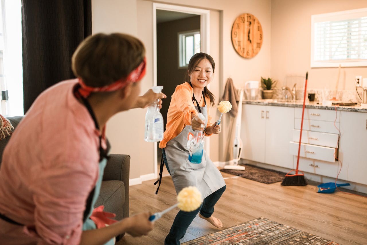 about-01 Asian couple having fun while cleaning their home, enhancing a cheerful atmosphere.